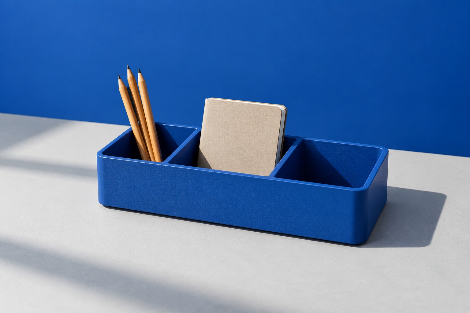 Fictional cobalt desktop organizer with pencils and a notebook